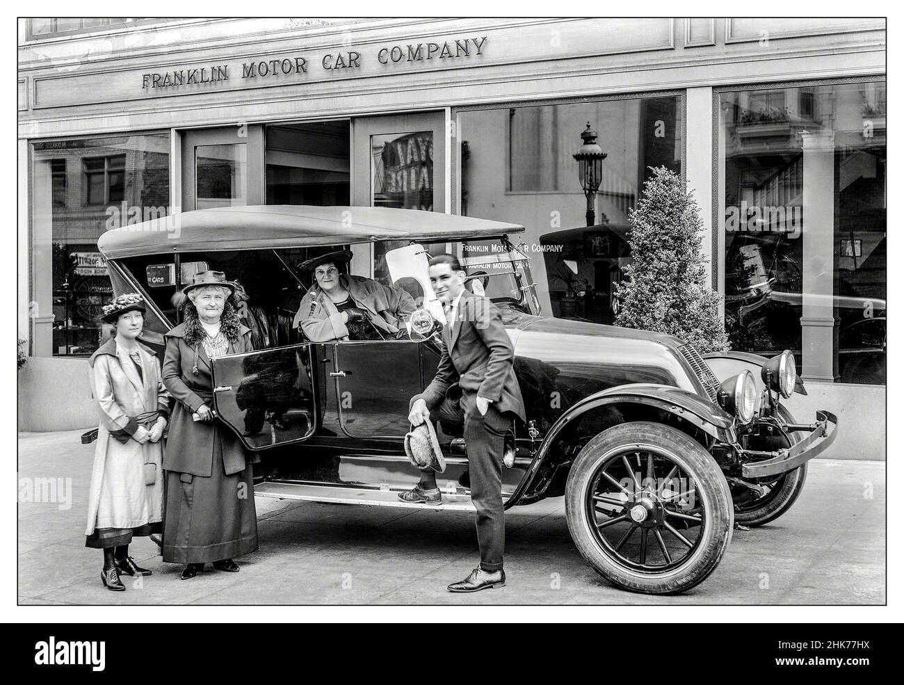 1900s Händler der Franklin Motor Car Company, Vorhofwagen und Verkäufer mit potenziellen weiblichen Kunden, die das Automobil untersuchen Stockfoto