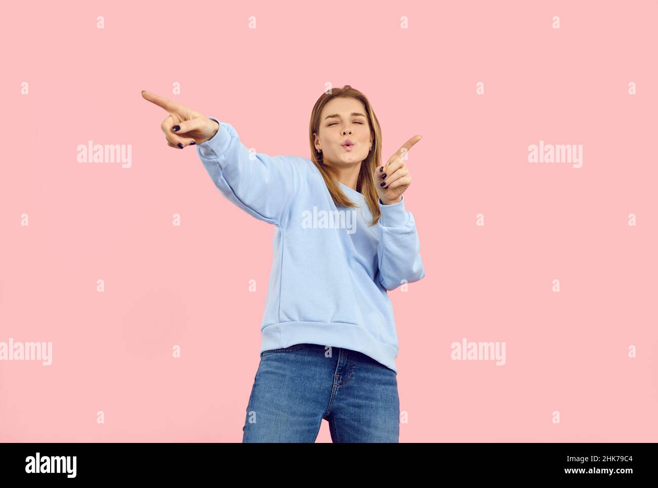 Lustige schöne Teenager-Mädchen tanzen zu moderner Musik isoliert auf einem rosa Hintergrund Stockfoto