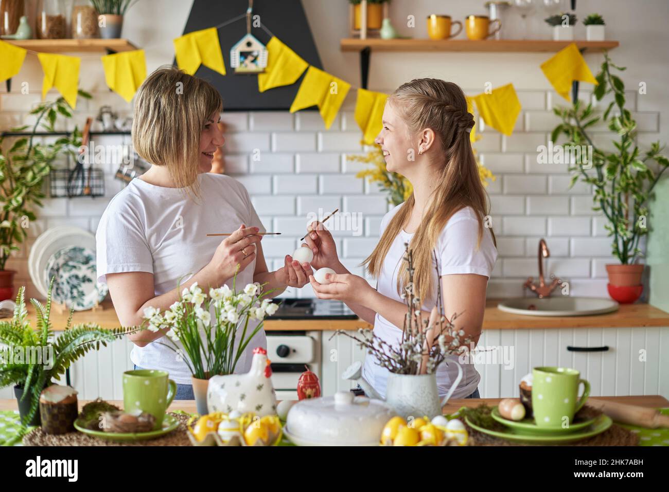 Mutter und Tochter bereiten sich auf die Osterferien vor und malen Eier. Stockfoto