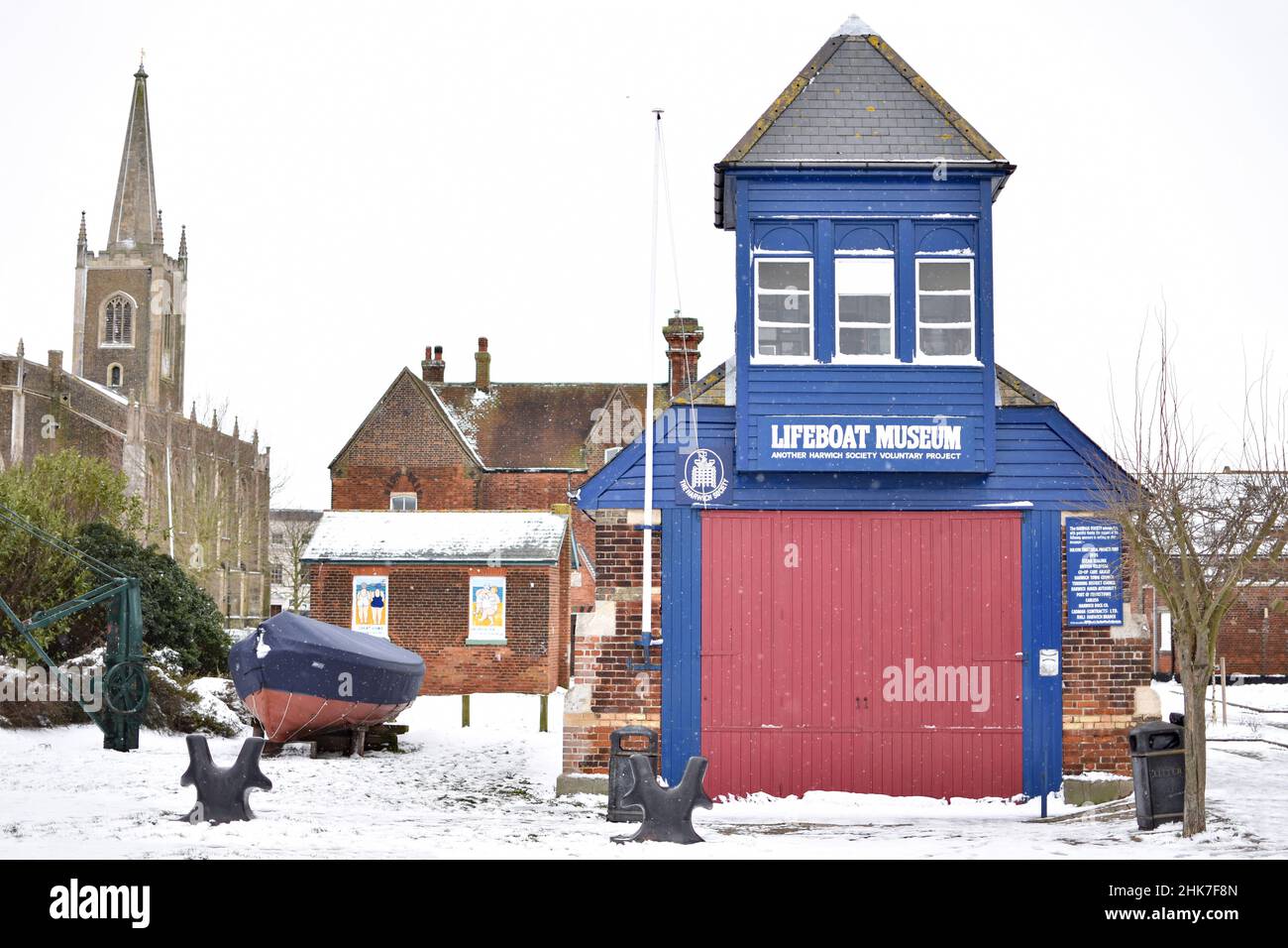 Das Harwich Lifeboat House wurde 1876 erbaut und ist heute ein Museum. Die Nikolaikirche steht an einem verschneiten Tag nach einem Wintersturm hinter sich. Harwich, North Essex, Großbritannien Stockfoto