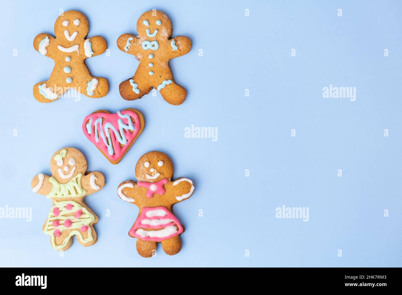Homosexuelle Plätzchen oder Lebkuchen mit Herz und buntem Sahnehäubchen für den Valentinstag auf blauem Hintergrund mit Kopierfläche. Stockfoto