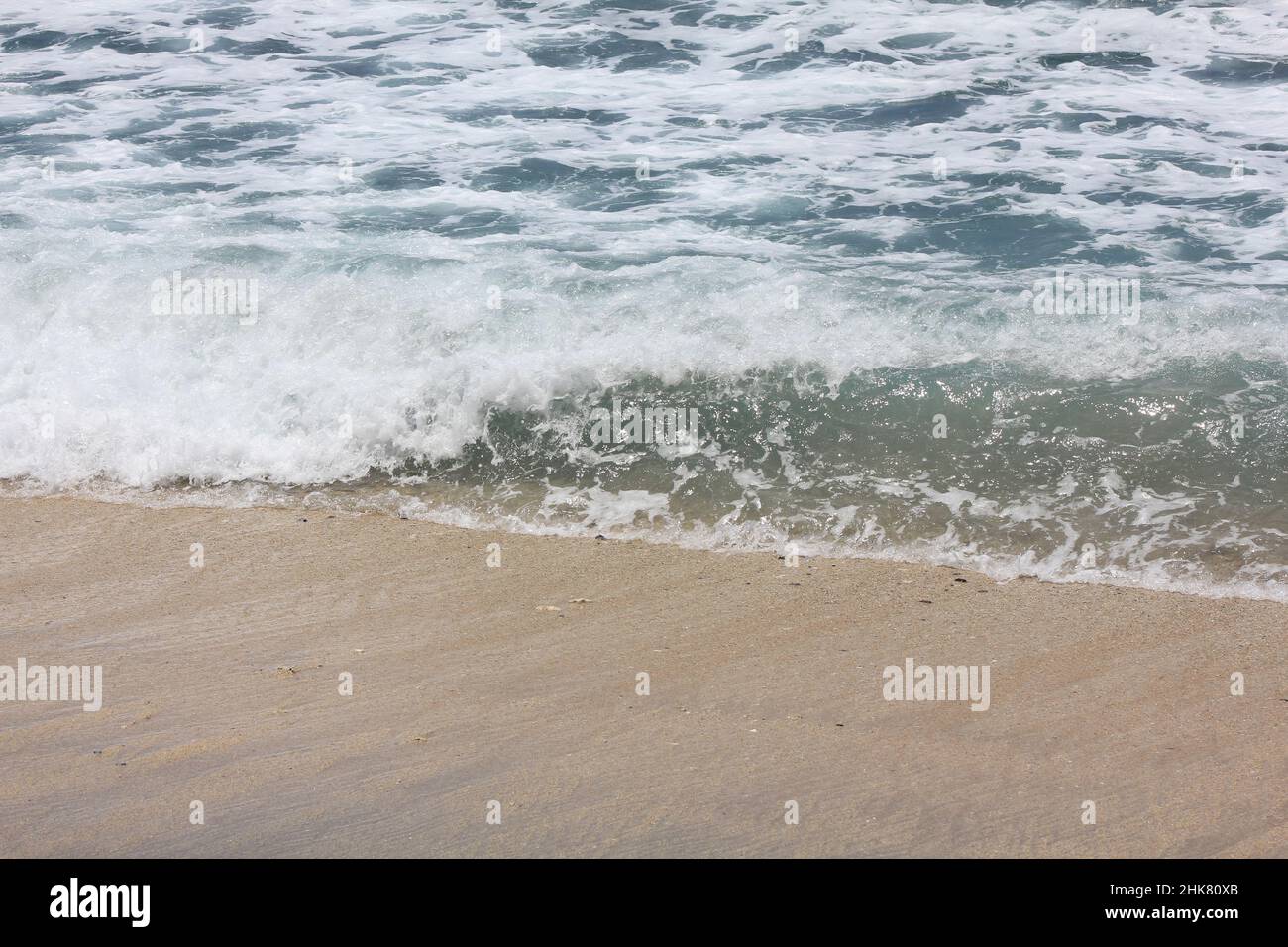 Hintergrund von Wellen und Schaum am Strand Stockfoto