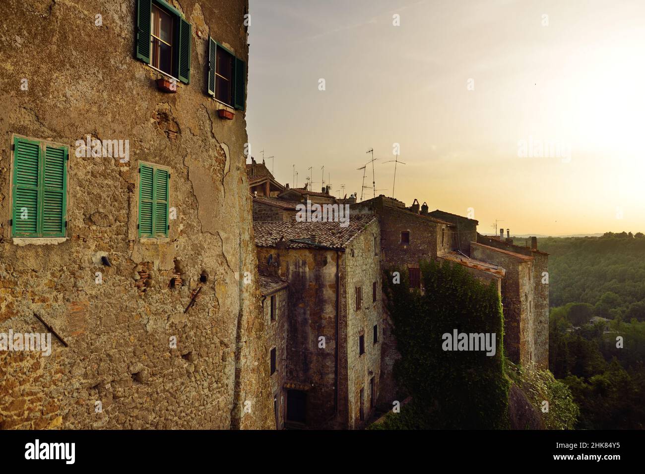 Blick auf die Stadt Pitigliano bei Sonnenuntergang, die sich auf einem vulkanischen Tuffsteinkamm befindet, der als das kleine Jerusalem bekannt ist und von üppigen Tälern umgeben ist. Etruskische Erbe, Gros Stockfoto