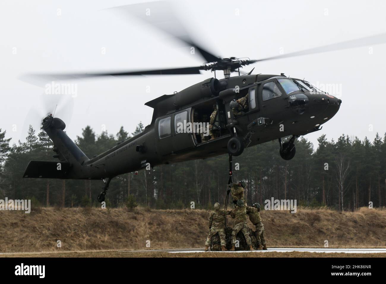 Luftangriffslehrer und Studenten führen Schlingentraglasoperationen mit UH-60 Blackhawk-Hubschraubern durch, die dem Bataillon 1st, dem Aviation Regiment 214th und dem Combat AVN 12th zugeordnet sind. Brigade, während des Luftansturzkurses der US-Armee im Trainingsgebiet Grafenwoehr, Deutschland, 27. Januar 2022. Das Combined Arms Training Center des Army Training Command 7th sponserte den zehntägigen Flugkurs, der von Ausbildern des Warrior Training Center der Army National Guard in Fort Benning, Georgia, angeboten wurde. Der Kurs schult Soldaten bei Luftangriffen, Schleuderbelastungen und Abseilen, um die Nutzung von h zu maximieren Stockfoto