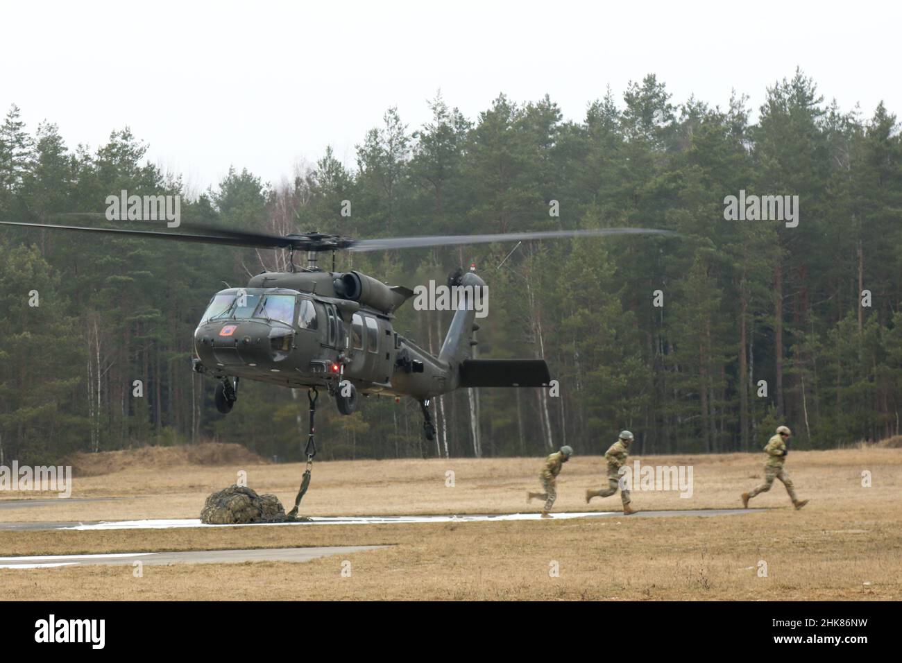 Luftangriffslehrer und Studenten führen Schlingentraglasoperationen mit UH-60 Blackhawk-Hubschraubern durch, die dem Bataillon 1st, dem Aviation Regiment 214th und dem Combat AVN 12th zugeordnet sind. Brigade, während des Luftansturzkurses der US-Armee im Trainingsgebiet Grafenwoehr, Deutschland, 27. Januar 2022. Das Combined Arms Training Center des Army Training Command 7th sponserte den zehntägigen Flugkurs, der von Ausbildern des Warrior Training Center der Army National Guard in Fort Benning, Georgia, angeboten wurde. Der Kurs schult Soldaten bei Luftangriffen, Schleuderbelastungen und Abseilen, um die Nutzung von h zu maximieren Stockfoto