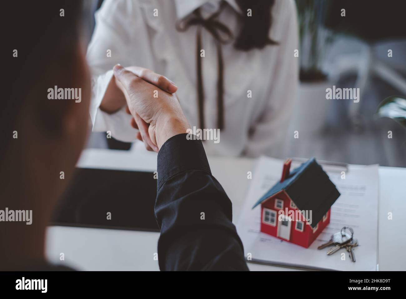 Geschäftsabschluss erfolgreich. Asiatische Menschen mit Agentur schütteln Hand nach Zeichen kaufen Hausvertrag abgeschlossen. Immobilienkonzept. Stockfoto