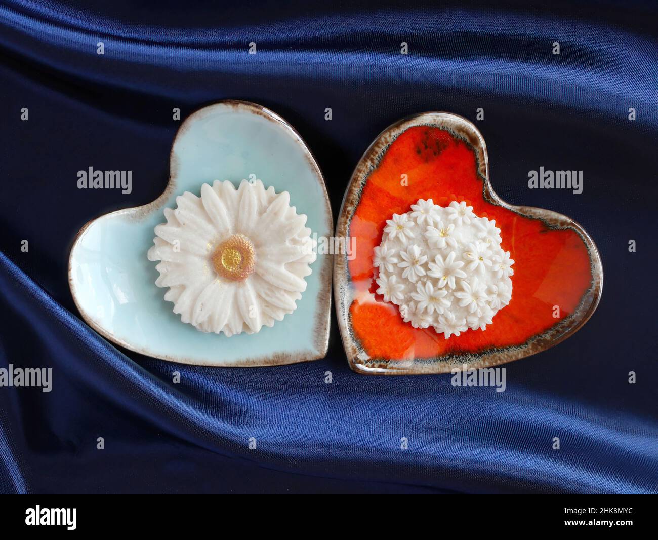 Draufsicht auf Sam Pan Nee Thai Traditional Dessert Handcraft Royal Famous thai Snack in orange und blau herzförmigen Teller mit blauem Satin Hintergrund Stockfoto