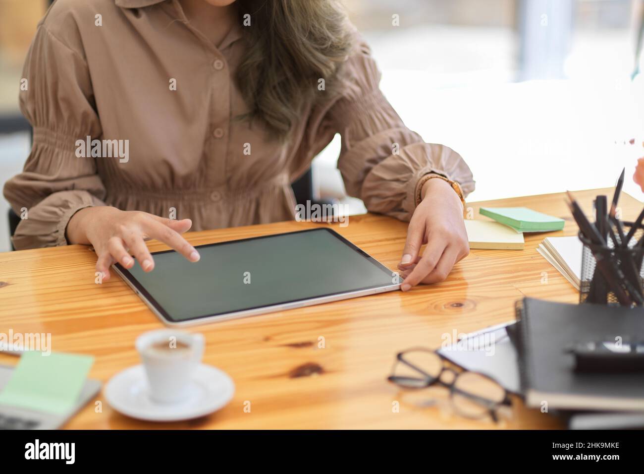 Freiberufliche Bloggerin bearbeitet ihr Food-Foto und lädt ihre Bewertungen auf Social Media über digitale Tablet-Computer. Zugeschnittenes Bild Stockfoto