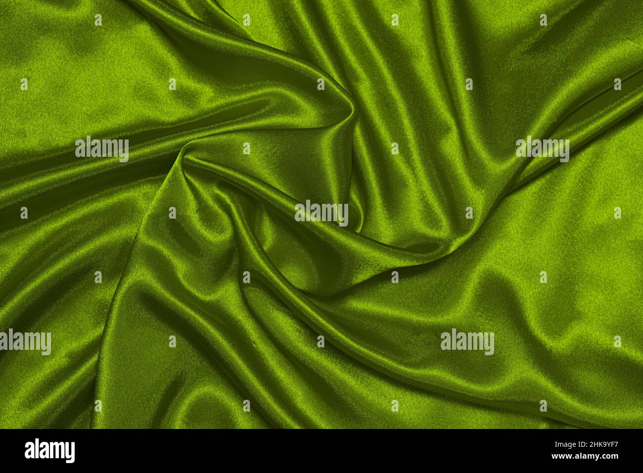 Textur aus zerknülltem grünem Olivseidenstoff, schönes Muster, Draufsicht. Stockfoto