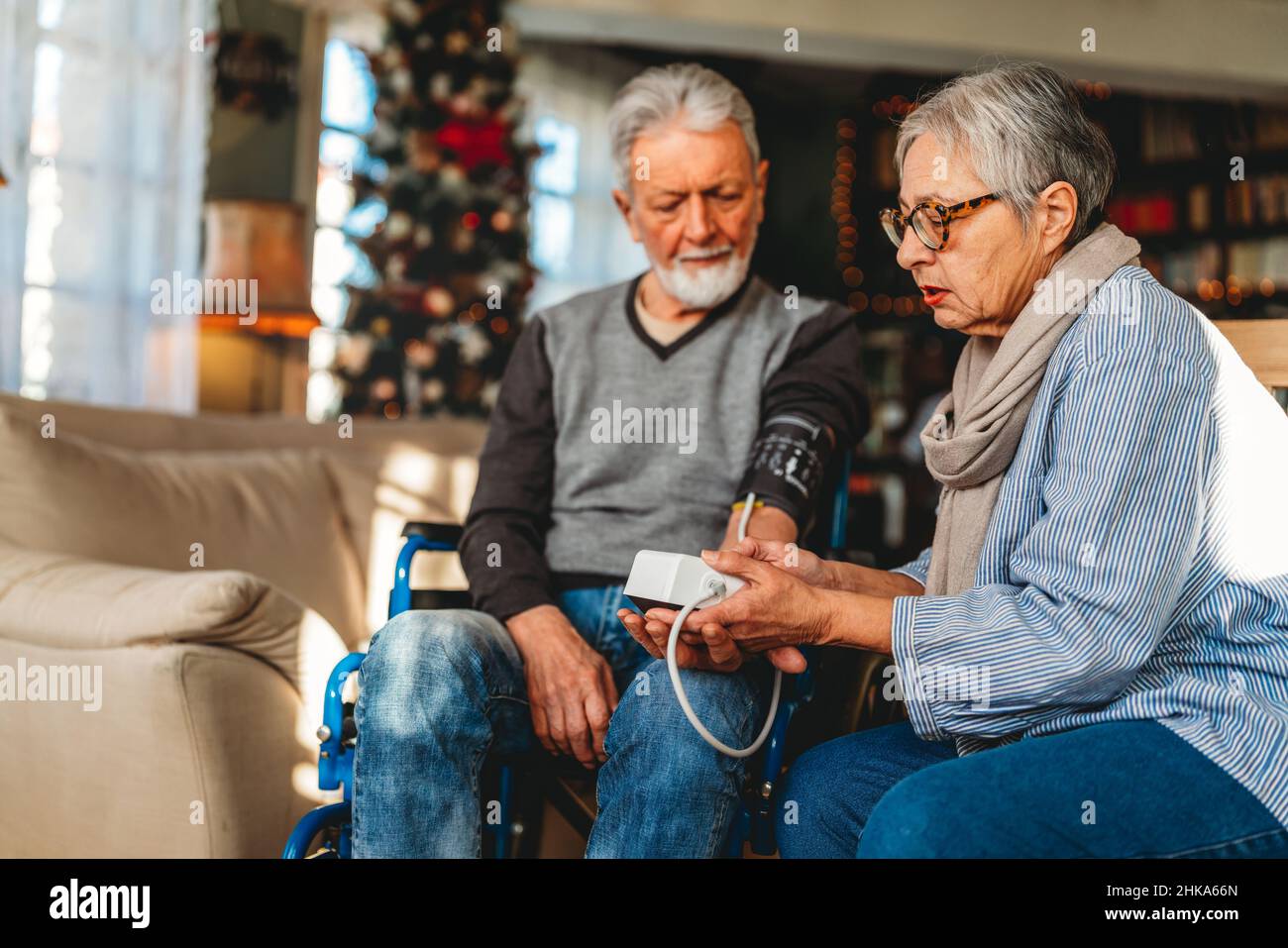 Seniorenpaar zu Hause, das den Blutdruck misst. Home Monitoring People Healthcare Konzept Stockfoto