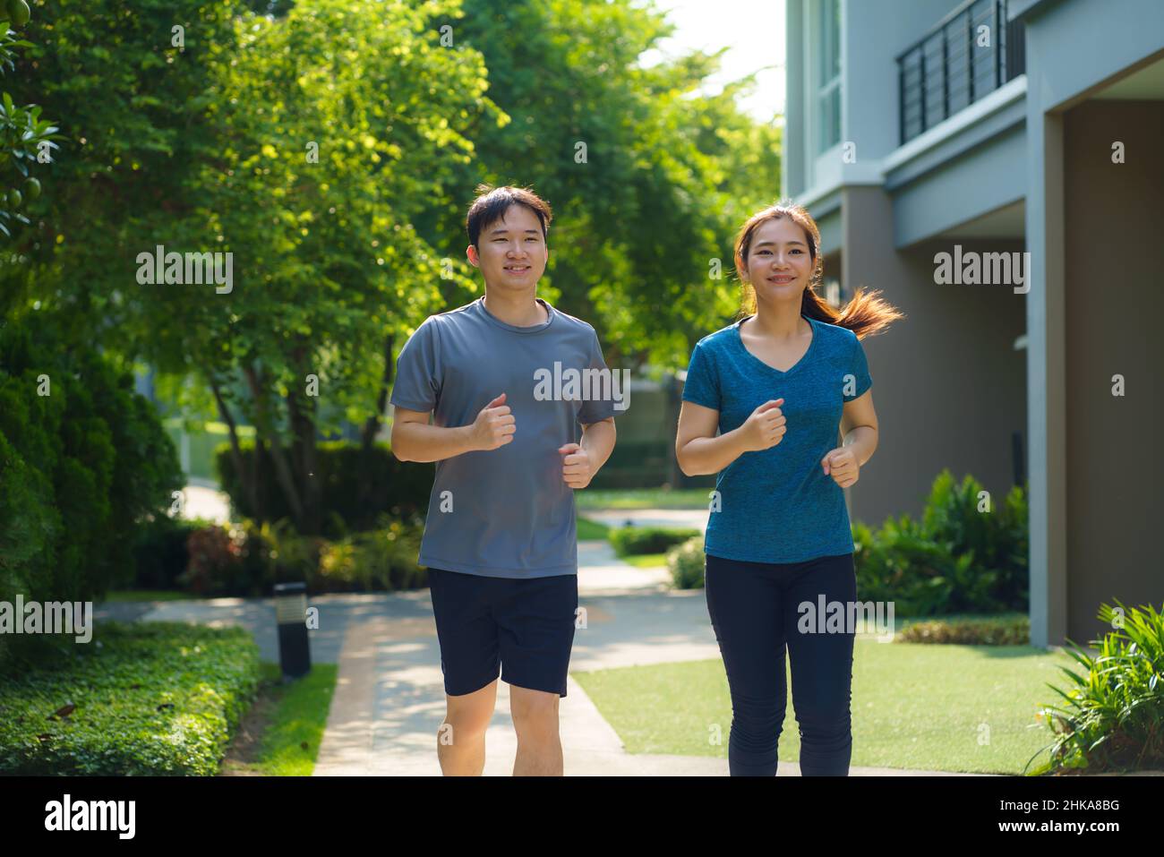 Asiatische Paare joggen in der Nachbarschaft für die tägliche Gesundheit und das Wohlbefinden, sowohl körperlich als auch geistig und einfach als Gegenmittel gegen den täglichen Stress und so Stockfoto