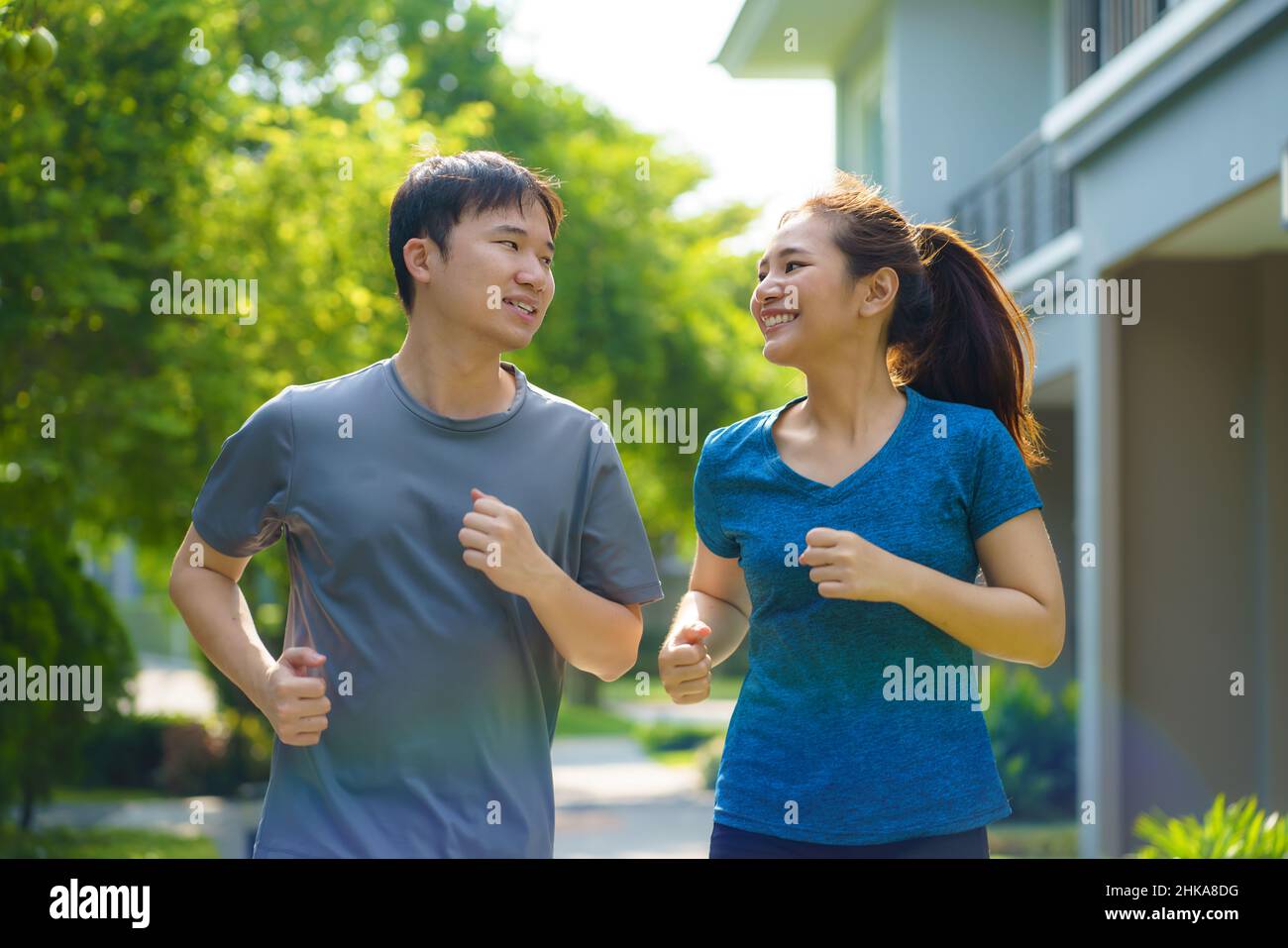 Asiatische Paare joggen in der Nachbarschaft für die tägliche Gesundheit und das Wohlbefinden, sowohl körperlich als auch geistig und einfach als Gegenmittel gegen den täglichen Stress und so Stockfoto