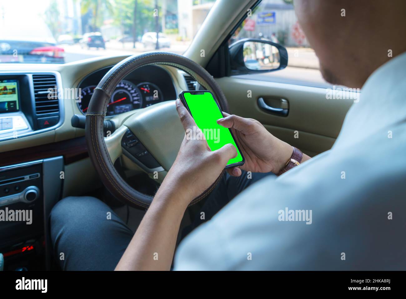 Auto fahren und Telefon benutzen. Abgelenkt Fahrer SMS mit Handy. Unverantwortlicher Mann, der im Verkehr mit dem Smartphone Nachrichten überprüft. Autom. Akzi Stockfoto