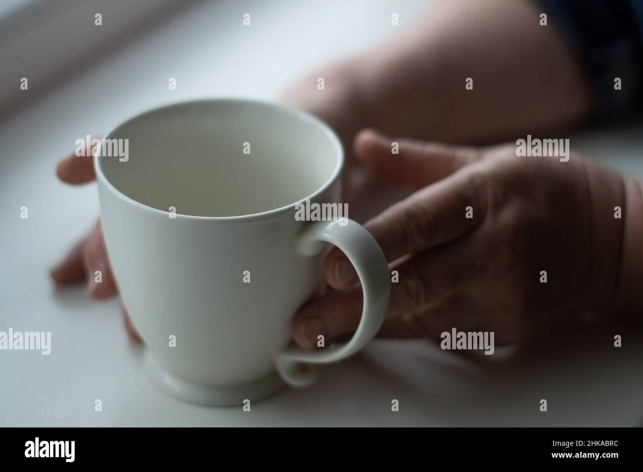Menschliche Hand hält weiße klassische Design-Kaffeetasse Stockfoto