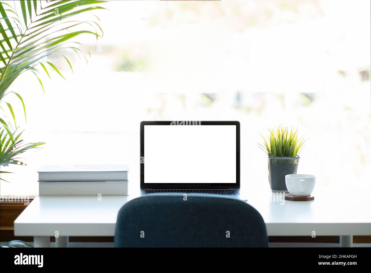 Nachbildung eines Laptops mit leerem weißen Bildschirm auf dem Arbeitsplatz im Heimbüro Stockfoto