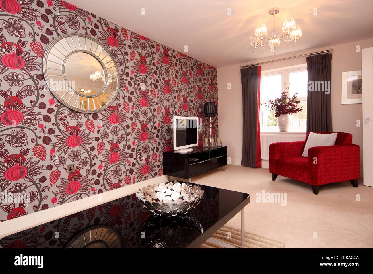 Wohnzimmer Lounge in dramatischen schwarz-roten und weißen Farbschemen, Blumenwand, dramatische Feature Wand, neues Haus zu Hause. Stockfoto