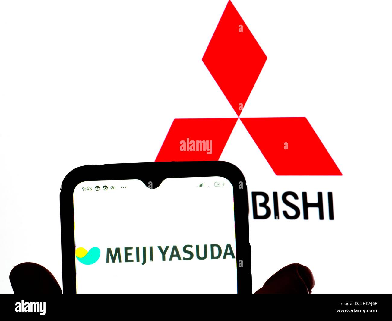 In dieser Abbildung wird das Meiji Yasuda Life-Logo auf einem Smartphone-Bildschirm mit einem Mitsubishi Corporation-Logo im Hintergrund angezeigt. Stockfoto