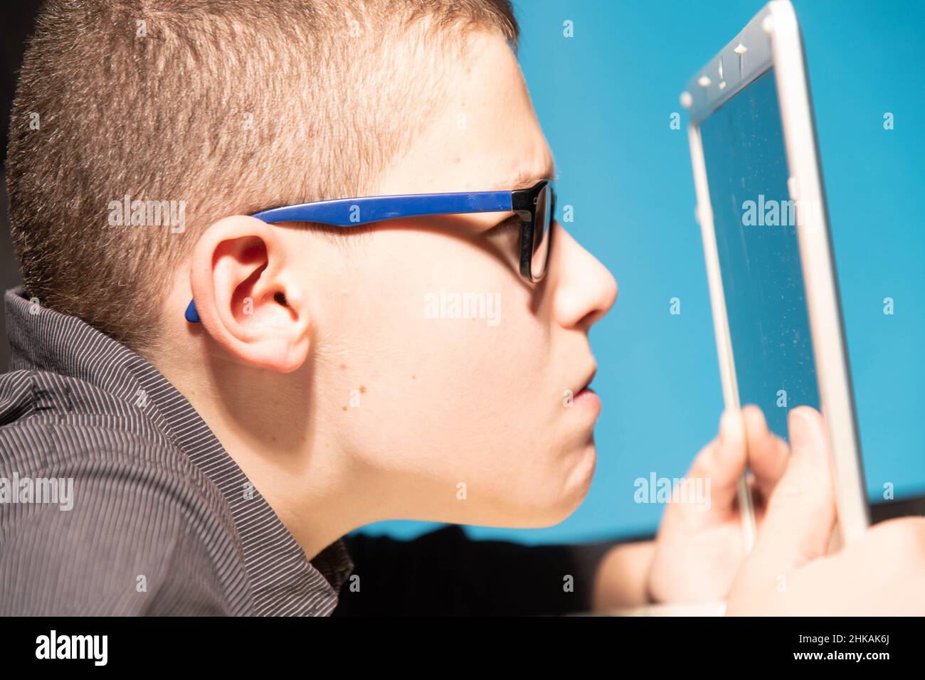 Junge zu Hause Schulbildung auf türkisfarbenem Hintergrund vor dem Laptop Stockfoto