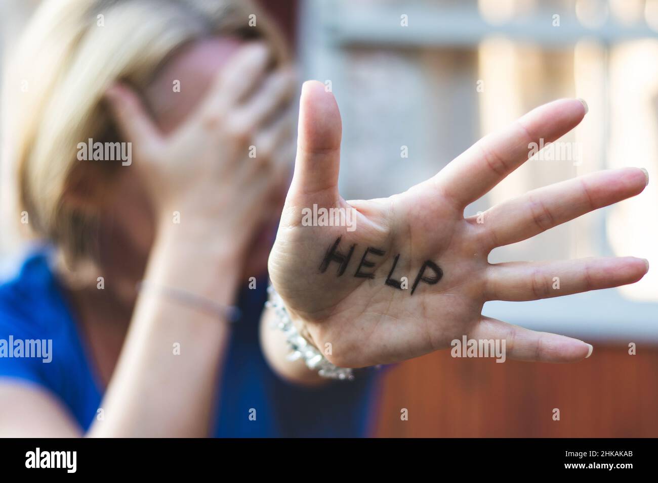 Frau, die gestikuliert, trägt ein Zeichen auf ihrer Hand. Depression-Konzept Stockfoto