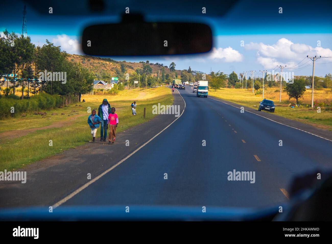 Blick vom Fahrer auf das Landkap, vorbei an einem Dorf auf einer kenianischen Autobahn durch das Great Rift Valley westlich von Nairobi, Kenia Stockfoto