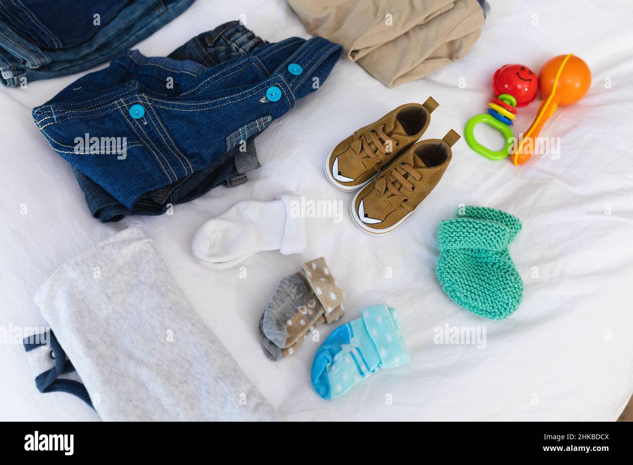 Blick von oben auf Babysachen und Kleidung auf dem Bett zu Hause Stockfoto