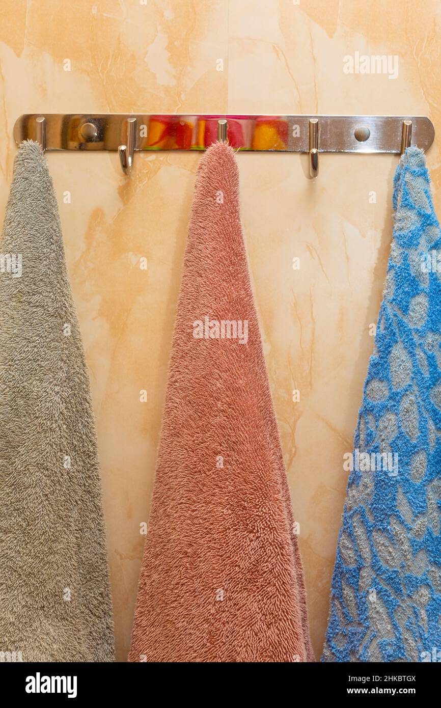 Bunte Handtücher hängen an einem Kleiderbügel im Badezimmer Stockfoto
