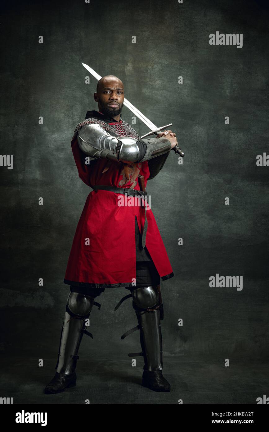 Porträt eines brutalen dunkelhäutigen Mannes, mittelalterlichen Kriegers  oder Ritters mit verwundeten Gesichtern, die eine Rüstung auf dunklem  Hintergrund tragen Stockfotografie - Alamy