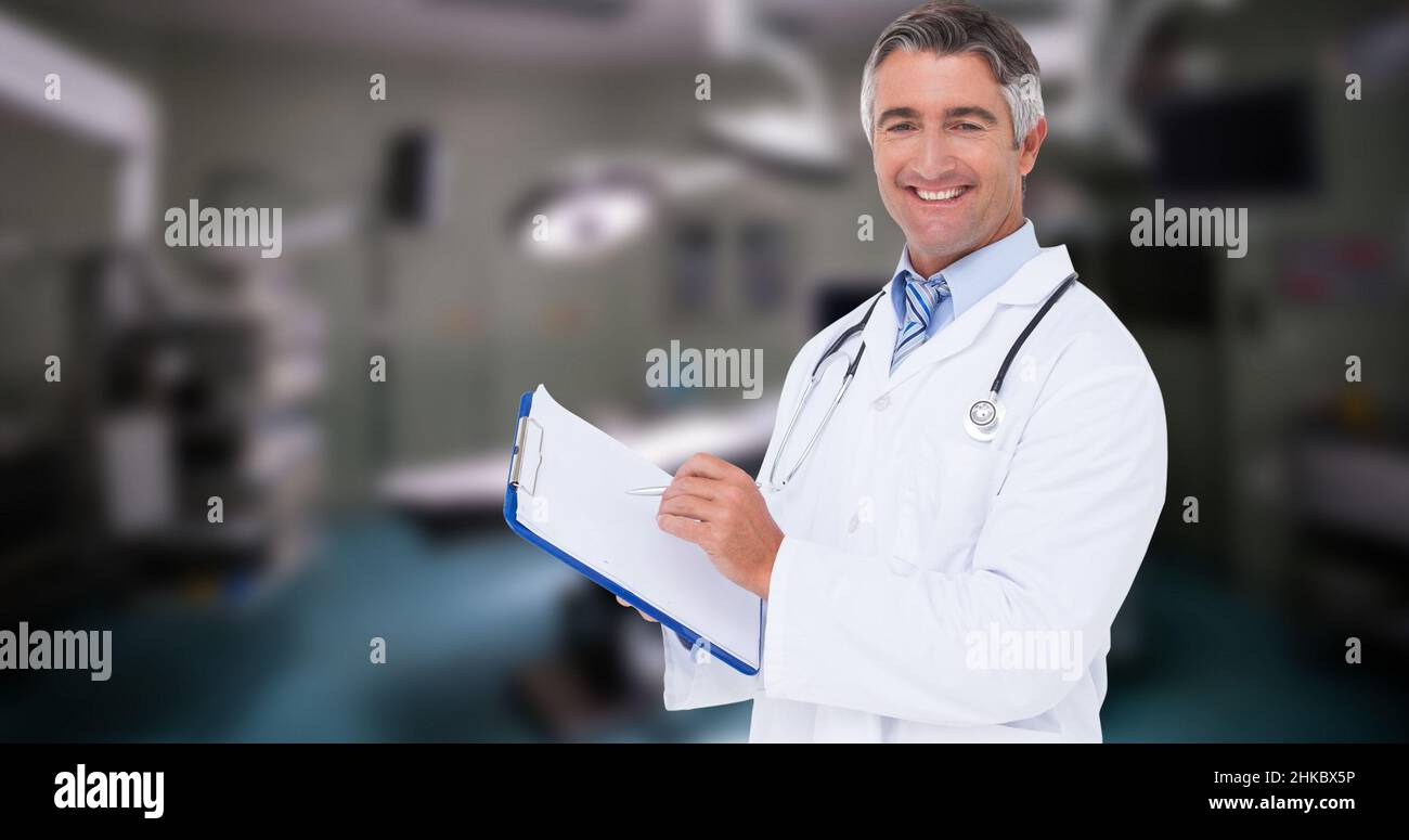 Porträt eines kaukasischen lächelnden reifen männlichen Arztes mit Zwischenablage im Krankenhaus Stockfoto