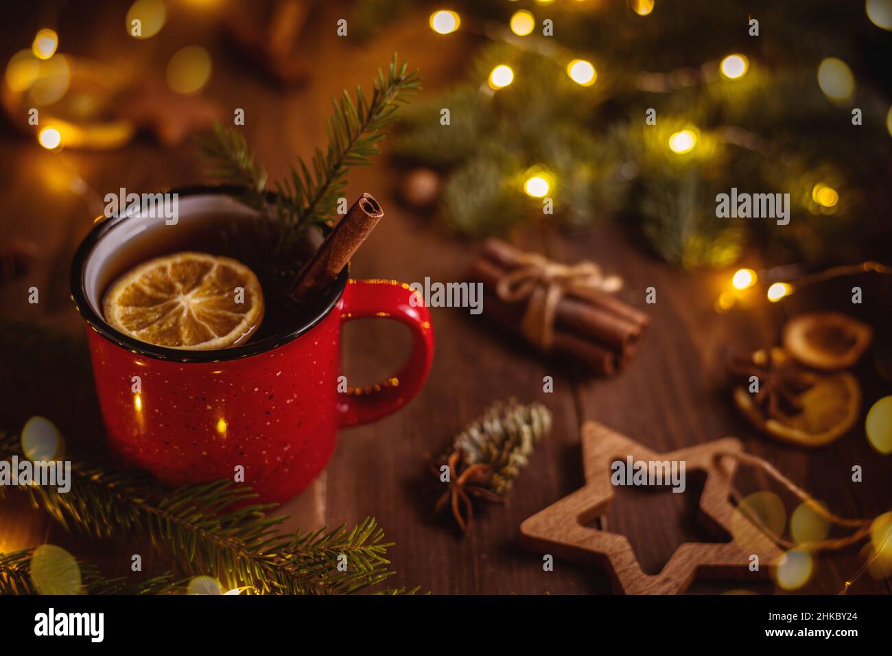 Eine rote Tasse mit einem Getränk, Zitrone und Zimt. Weihnachten, Neujahrskomposition. Glühwein, Tee Stockfoto