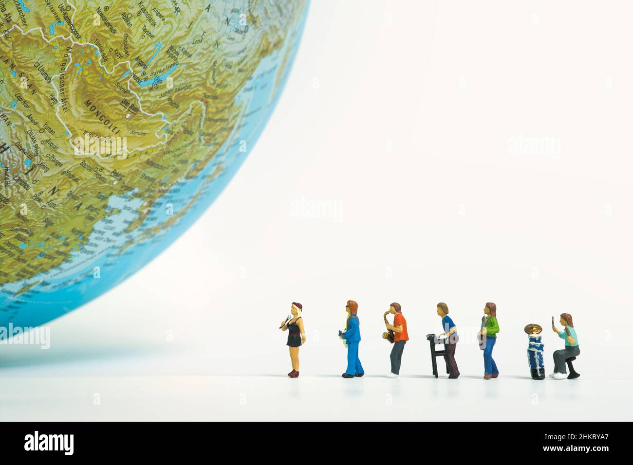 Die Musikband steht in einer Reihe vor einem riesigen Globus Stockfoto