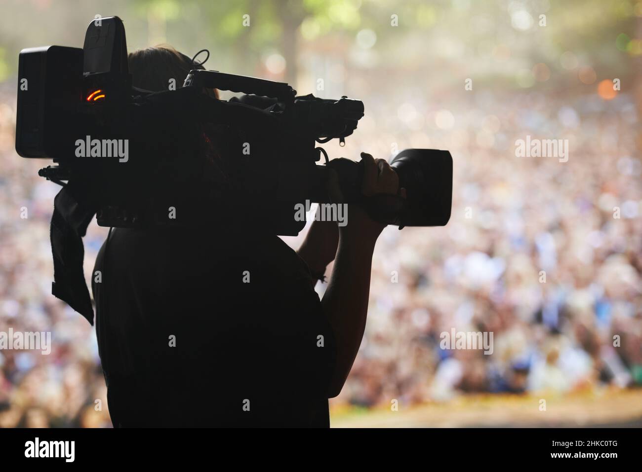 Die Spannung festhalten. Eine Silhouette eines Kameramanns, der ein Ereignis filmt. Stockfoto