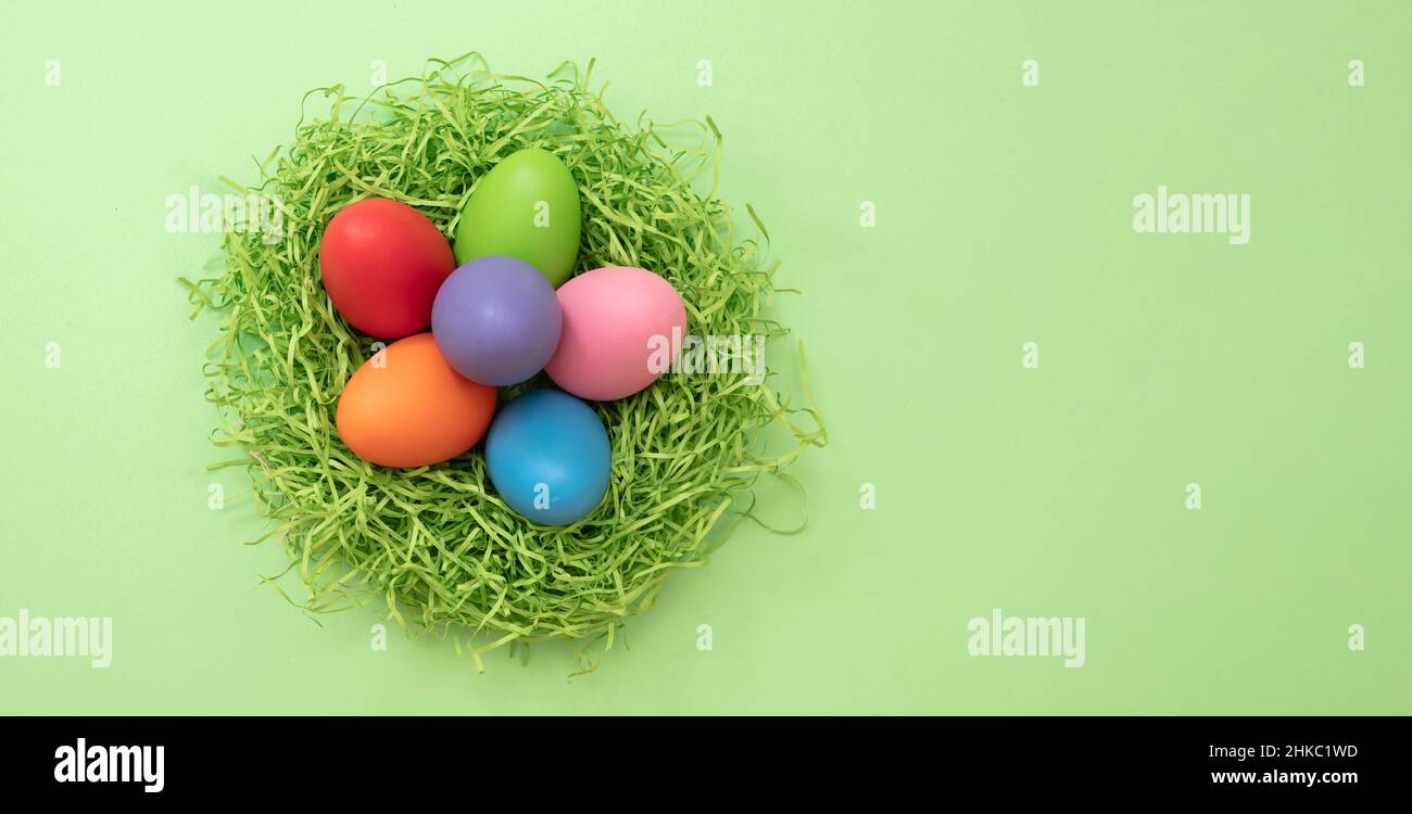 Ostern, Frühlingsfest, Pastellfarbe malen Ei in einem Nest, grüner Hintergrund, Draufsicht, Kopierraum. Stockfoto