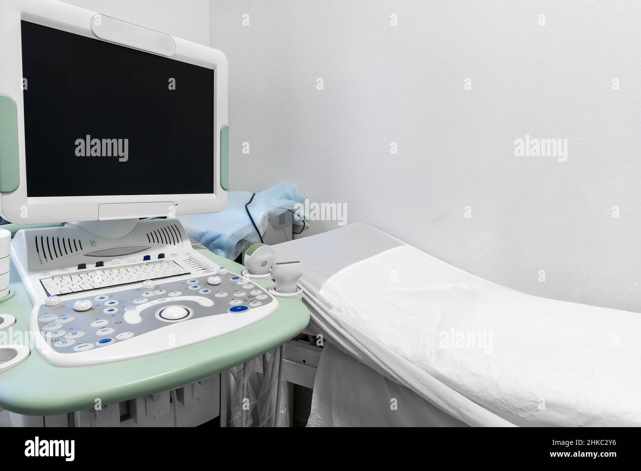 Arztpraxis mit Couch und Diagnose-Tools. Nahaufnahme des Ultraschallgeräts in der Klinik. Modernes Krankenhaus mit High-Tech-Ausstattung. Gesundheitswesen Stockfoto