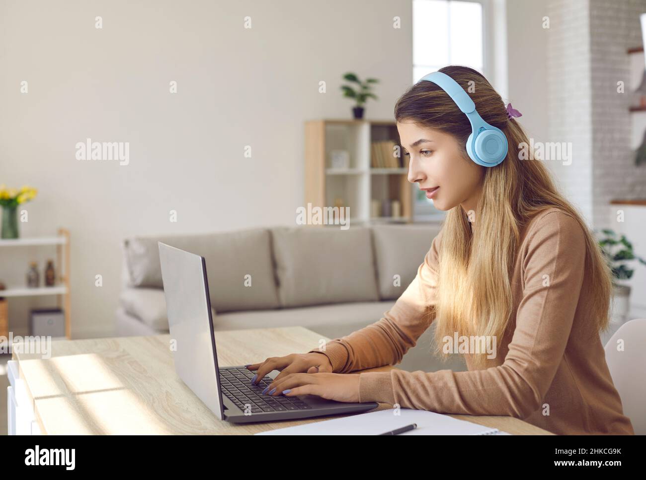 Mädchen mit Kopfhörern lernen online auf dem Laptop zu Hause Stockfoto