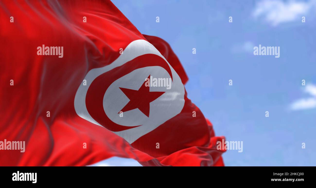 Detail der Nationalflagge Tunesiens, die an einem klaren Tag im Wind winkt. Demokratie und Politik. Patriotismus. Maghreb-Land in Nordafrika. Selecti Stockfoto