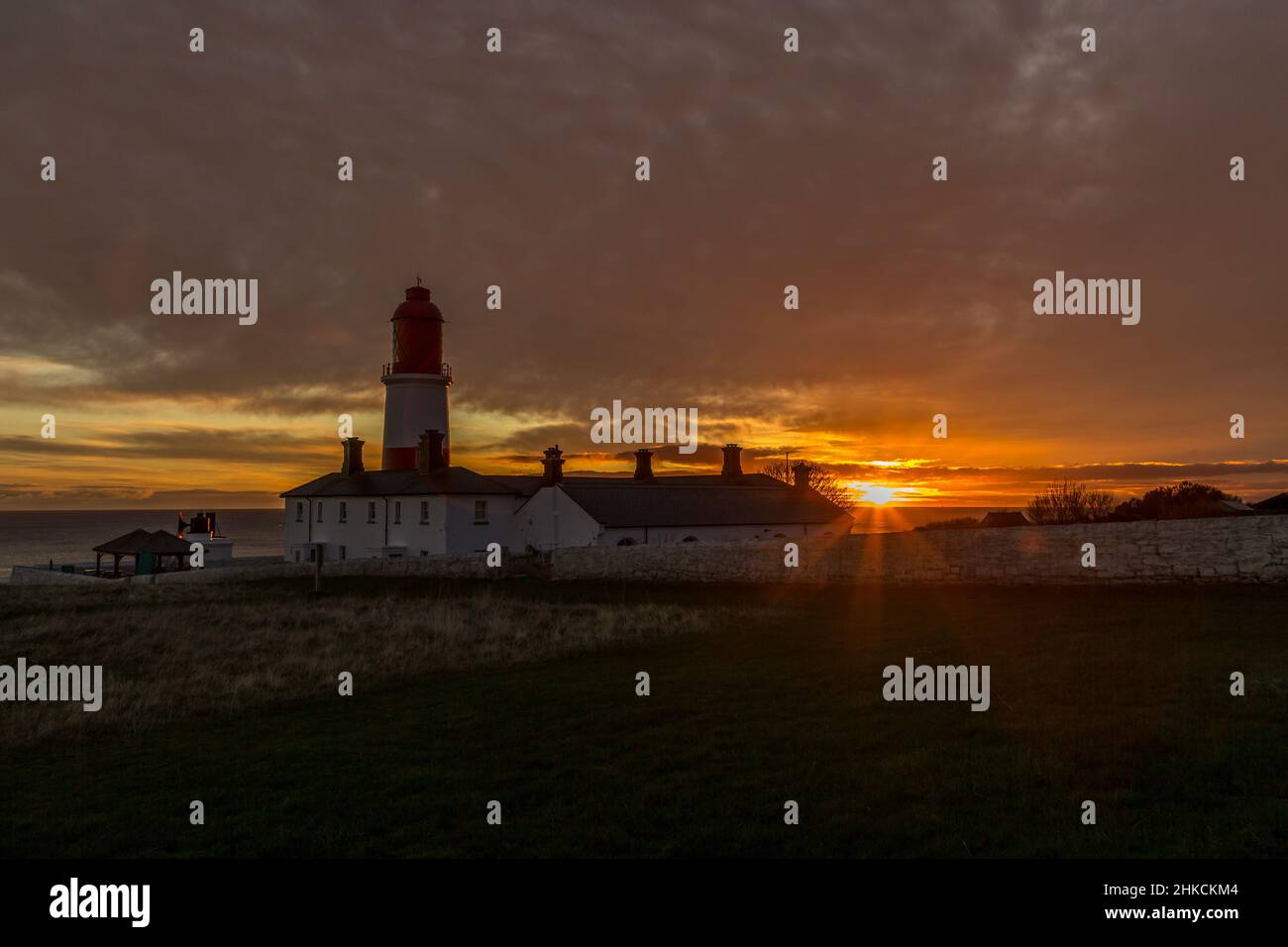 Der rot-weiß gestreifte, 23 Meter hohe Souter Lighthouse und die Leas in Marsden, South Shields, England, wenn die Sonne aufgeht Stockfoto