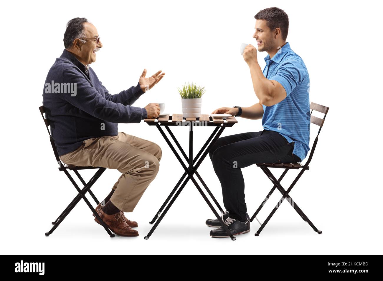 Junger und reifer Mann sitzt an einem Tisch und hat einen Kaffee isoliert auf weißem Hintergrund Stockfoto