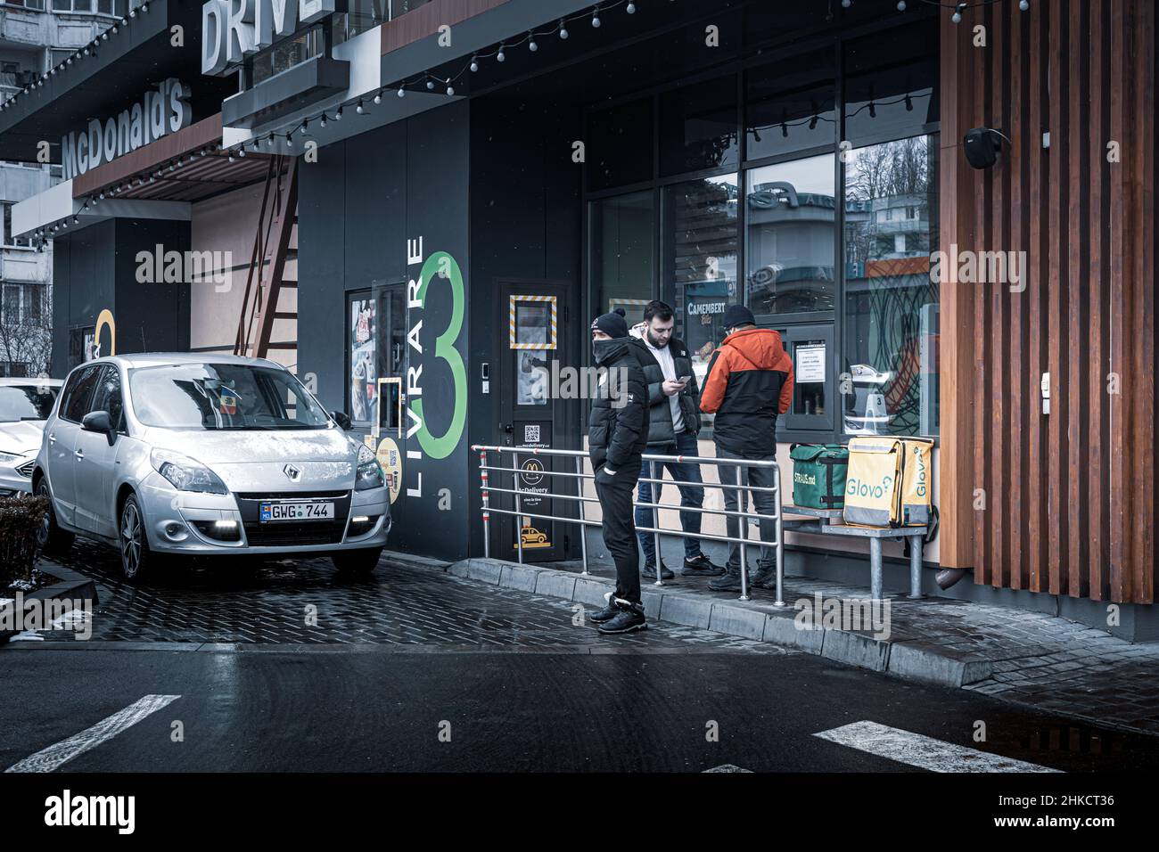 Chisinau, Moldawien - 23. Januar 2022 McDonald's Drive. Am McDonald's Drive stehen Autos an. Die Mitarbeiter des Glovo Delivery Service warten auf die Bestellung Stockfoto