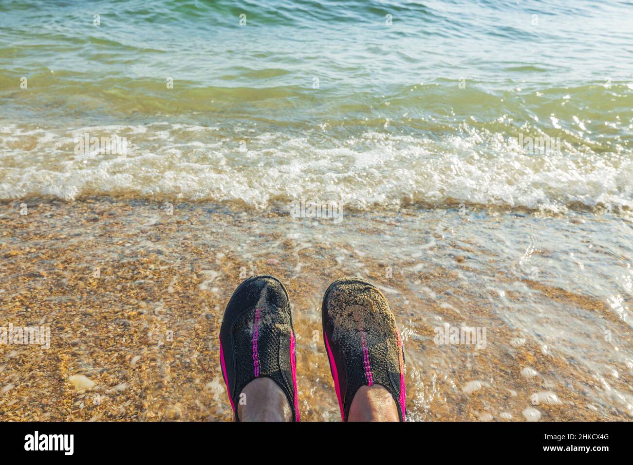 Blick auf Badeschuhe auf den Füßen eines Mannes vor dem Hintergrund des Meeres. Griechenland. Stockfoto