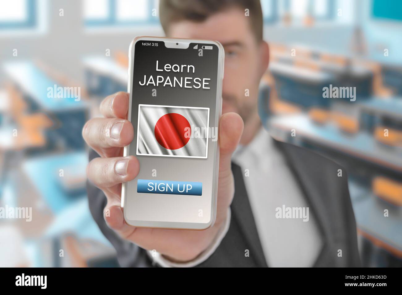 Online-Konzept Lernen Sie die japanische Sprache mit einer Person, die die E-Learning-App auf einem Mobiltelefon mit der Flagge Japans zeigt Stockfoto