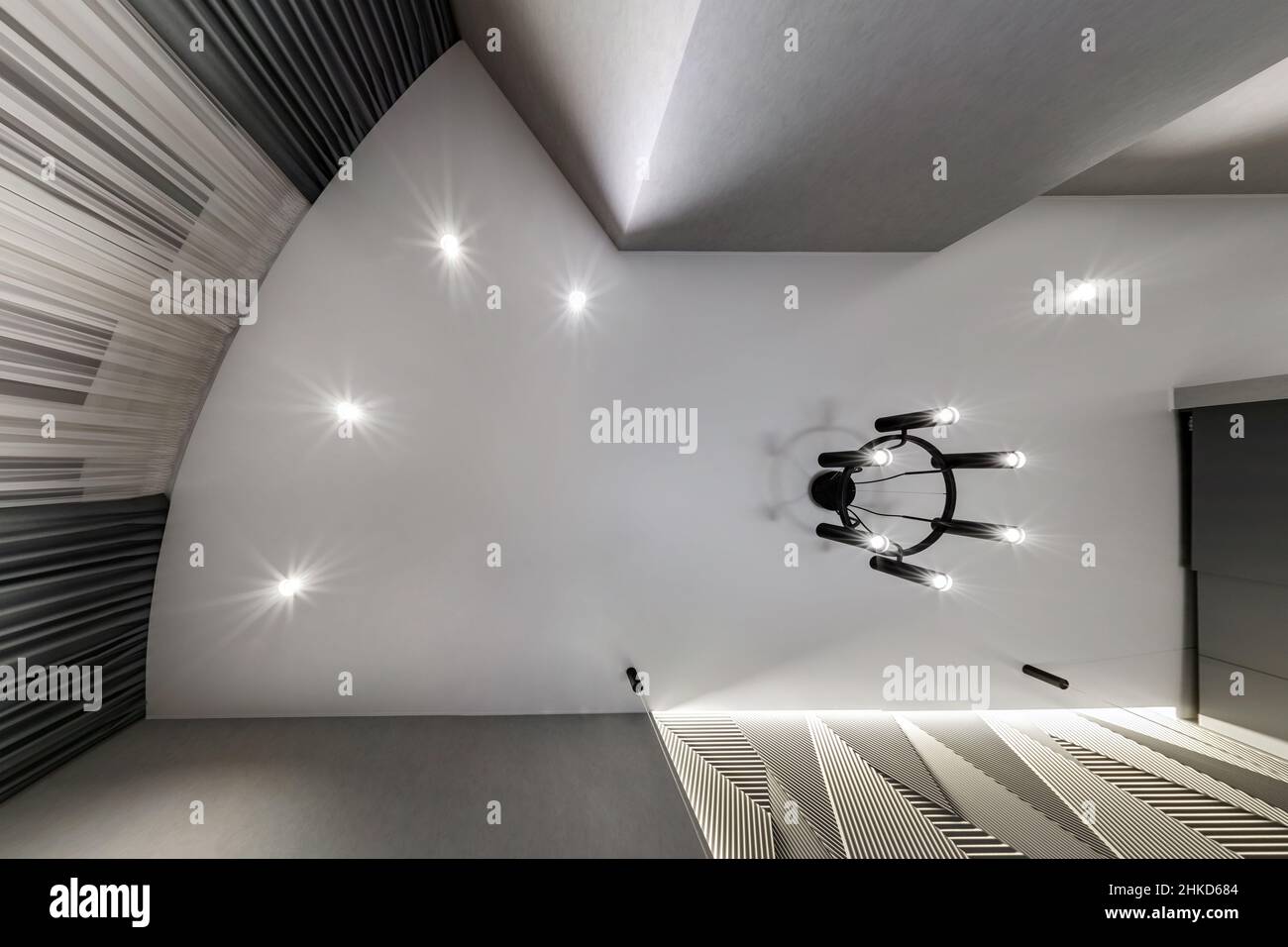 Abgehängte Decke mit Halogenstrahlern und Trockenmauerkonstruktion im leeren Raum in Wohnung oder Haus. Stretchdecke weiß und komplex. Stockfoto