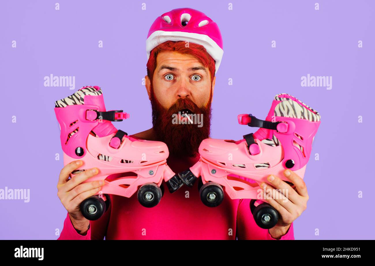 Bärtiger Mann mit Rollschuhe und Schutzhelm. Sportausrüstung. Typ mit Rollschuhlaufen. Stockfoto