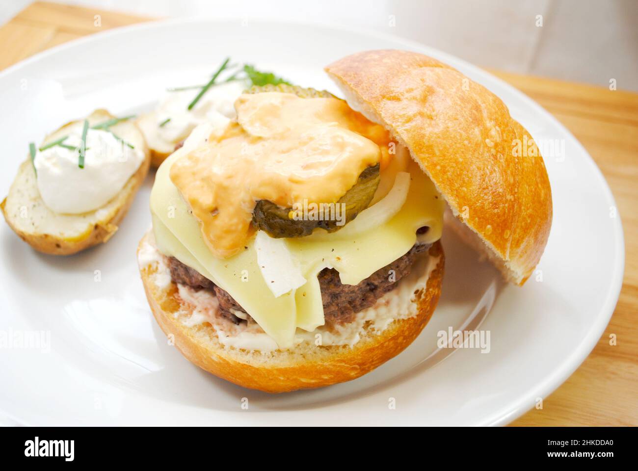 Köstlicher Beef Burger mit Käse, Zwiebeln, Pickles und Thousand Island Dressing Stockfoto