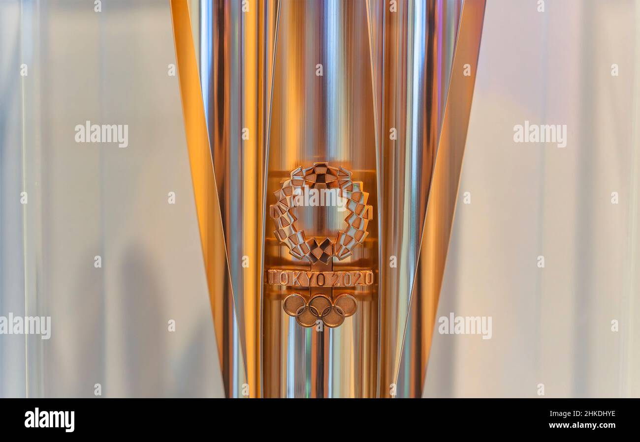 tokio, japan - 24 2021. august: Nahaufnahme des Logos der fünf olympischen Ringe und des harmonisierten karierten Emblems von Asao Tokolo auf der goldenen Fackel der To Stockfoto