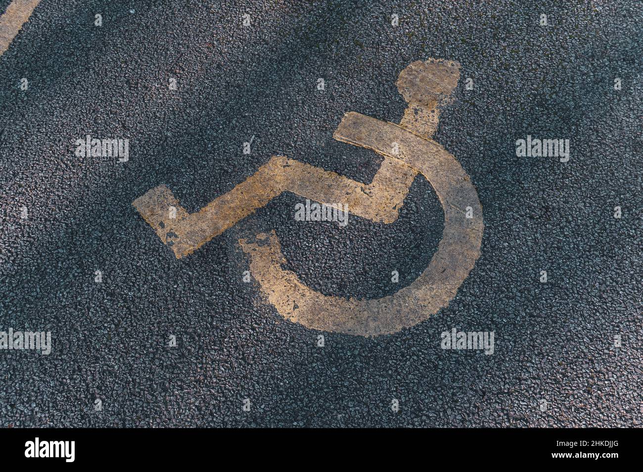 Behindertenparkplätze. Barrierefreier Parkplatz. Blaues Abzeichen. Gelbes Rollstuhlschild auf dem Boden Stockfoto