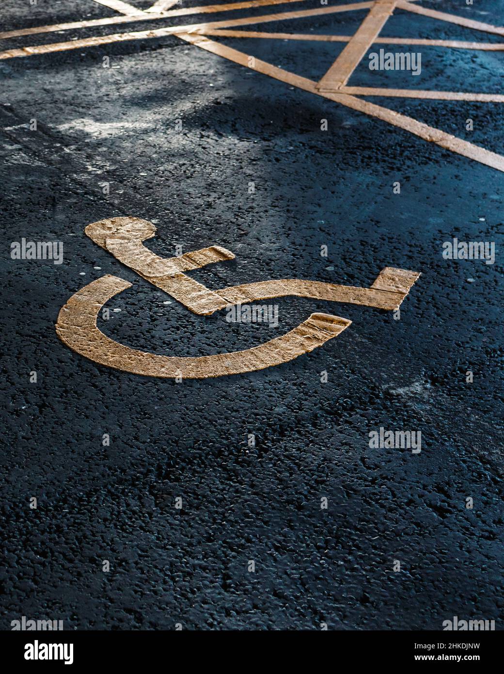 Behindertenparkplätze. Barrierefreier Parkplatz. Blaues Abzeichen. Gelbes Rollstuhlschild auf dem Boden Stockfoto