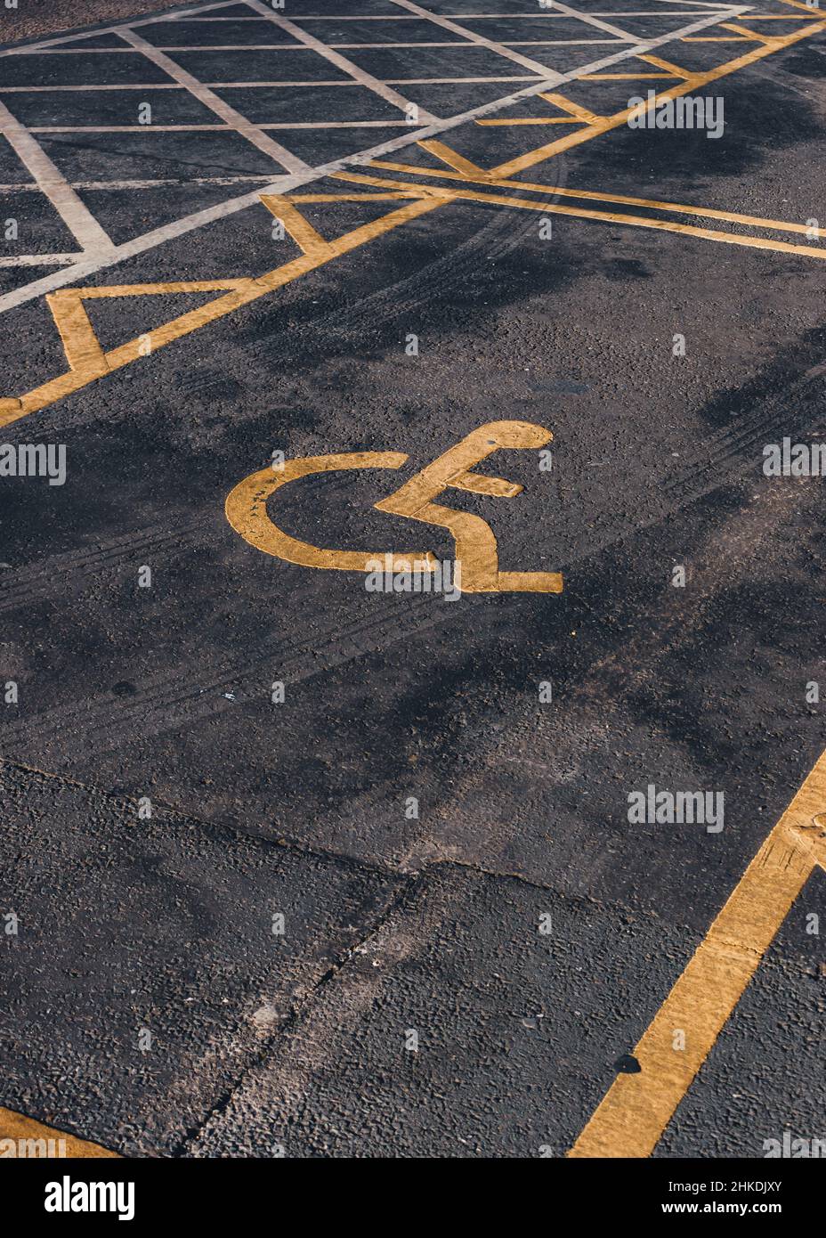 Behindertenparkplätze. Barrierefreier Parkplatz. Blaues Abzeichen. Gelbes Rollstuhlschild auf dem Boden Stockfoto