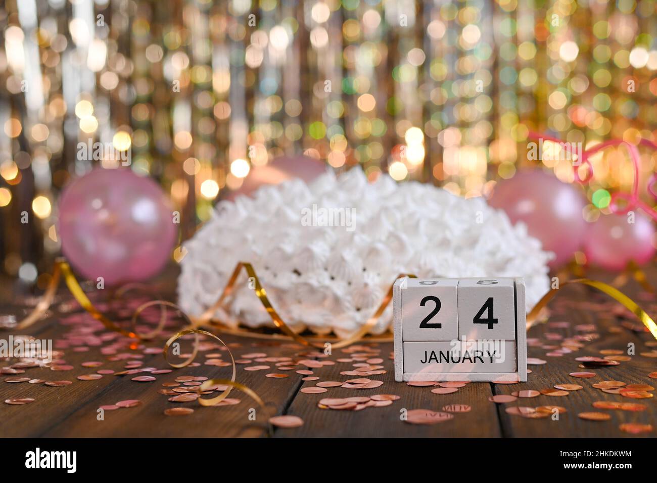 Weiße Geburtstagstorte. Der Holzkalender zeigt den 24. Januar. Stockfoto