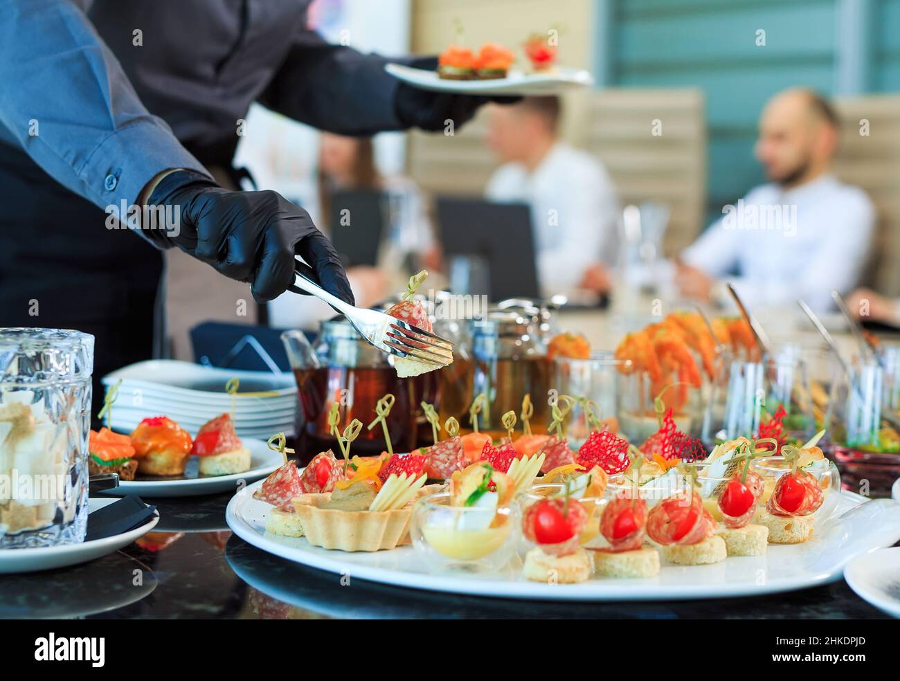 Der Kellner legt Essen für die Verpflegung aus Stockfoto