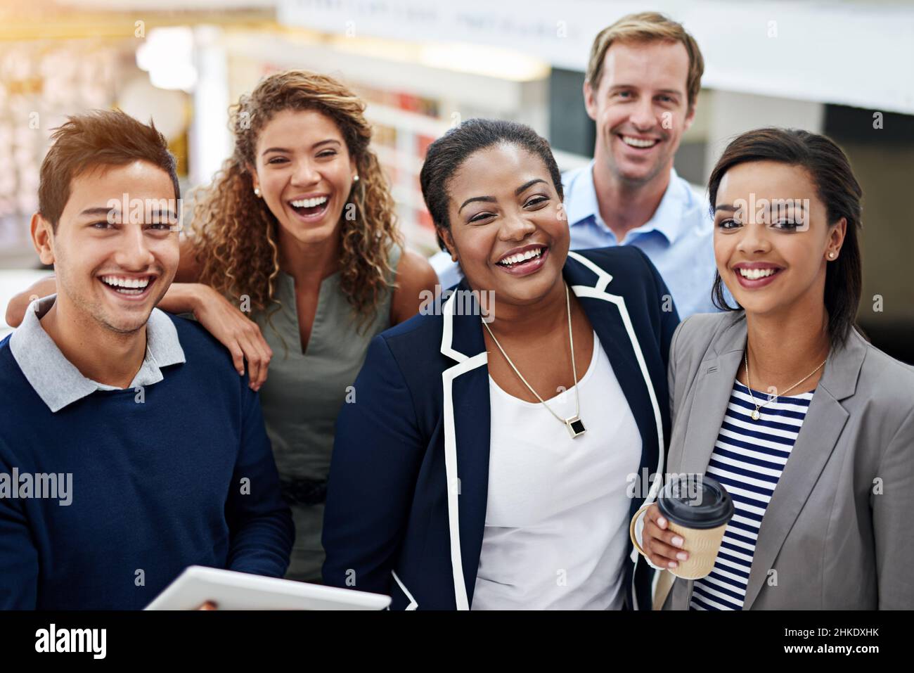 Zusammenkommen für den Erfolg des Teams. Porträt einer Gruppe lächelnder Mitarbeiter, die in einem Büro stehen. Stockfoto